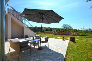 een patio met een tafel en een parasol bij Casa Nini in Rovinj