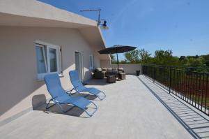 dwa niebieskie krzesła i parasol na balkonie w obiekcie Casa Nini w Rovinj +5 zdjęć