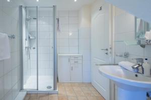 a white bathroom with a shower and a sink at Reethüs Brodersen in Risum-Lindholm