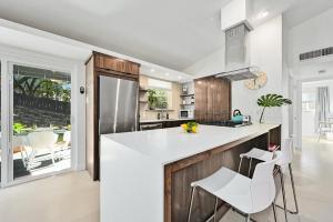 a kitchen with white countertops and wooden cabinets at The Guava Door - Cheerful Mid-Century - big yard, free parking in Austin