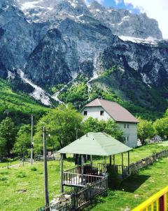 tenda in un campo con montagne sullo sfondo di Bujtina Kometa a Theth