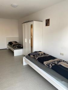 two beds in a room with white walls at nJoy! Monteurhaus in Altbach mit Garten & Balkon in Altbach