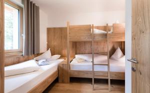 a bedroom with two bunk beds and a window at Hotel Gasserhof in Bressanone