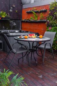 a table with two chairs and a plate of fruit on it at JASMIN DE NUIT - Villa FOURNAISE in Le Tampon