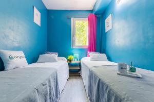 2 letti in una camera con pareti blu di ARAGON PLUS ARYSAL a Salou