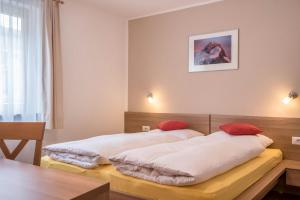 1 dormitorio con 2 camas y almohadas rojas en Hilber App Fermeda, en Villnoss