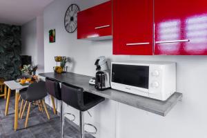 a kitchen with a counter with a microwave and some chairs at JASMIN DE NUIT - Villa FOURNAISE in Le Tampon