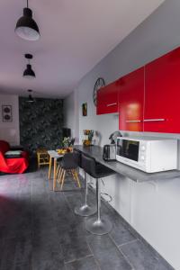 a kitchen with red cabinets and a table with a microwave at JASMIN DE NUIT - Villa FOURNAISE in Le Tampon