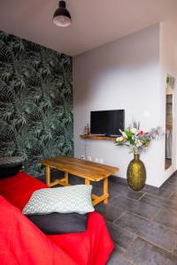 a living room with a red couch and a table at JASMIN DE NUIT - Villa FOURNAISE in Le Tampon