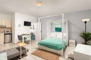 a bedroom with a green bed and a kitchen at ''Meraviglia casa'' Ariadne in Kato Daratso