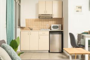 a kitchen with white cabinets and a microwave at ''Meraviglia casa'' Ariadne in Kato Daratso +33 photos