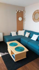 a living room with a blue couch and a coffee table at Comme dans un phare in Arcachon