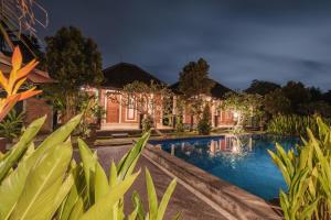 een uitzicht op een huis met een zwembad bij Dhiari Guest House in Ubud