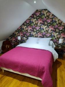 TournavauxにあるChalet à L'orée du bois avec parkingのベッドルーム1室(花の壁のベッド1台付)