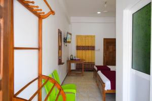 a room with a bed and a table and a chair at Hotel Theevanni Inn in Trincomalee