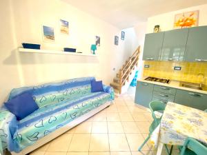 un soggiorno con divano blu in cucina di Appartamento Via Trentino a San Teodoro
