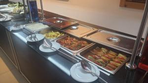 uma linha de buffet com muitas bandejas de comida em em MERİÇ HOTEL TURUNÇ em Beşevler