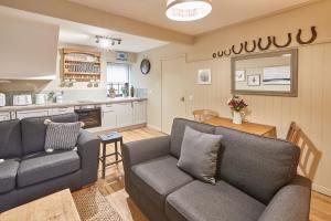 sala de estar con 2 sofás y cocina en Beadnell Bay Cottage, en Beadnell