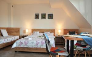a bedroom with two beds and a table and chairs at Pokoje Gościnne U Anny in Nowy Targ