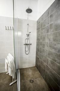 uma casa de banho com um chuveiro e toalhas brancas em Le Fanal em Argelès-sur-Mer