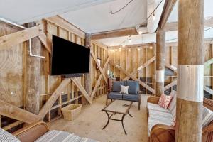 a living room with wooden walls and a flat screen tv at 307 W Indian - The Prickly Pear in Folly Beach
