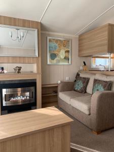 a living room with a couch and a fireplace at Swift bordeaux 24 in Dunoon