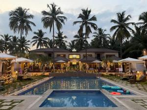 a resort with a swimming pool and palm trees at Thavika Royal Destiny Resort in Malaiyāndipattanam