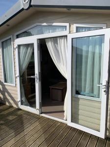 an open sliding glass door on a deck at Swift bordeaux 24 in Dunoon