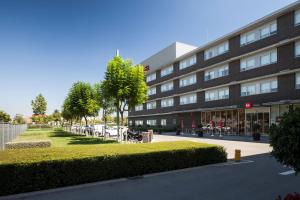 a large building with a park in front of it at Ibis Barcelona Aeropuerto Viladecans in Viladecáns