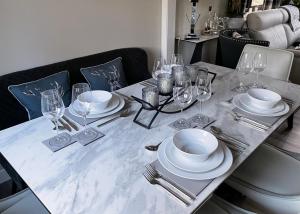 a table with plates and wine glasses on it at Luxury Riverside Lodge, Blair Atholl in Pitlochry