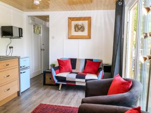 a living room with a couch and red pillows at Harvest Lodge in Haywards Heath