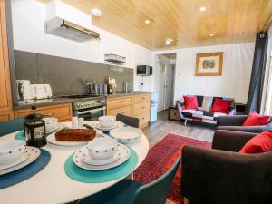 a kitchen and living room with a table and chairs at Harvest Lodge in Haywards Heath