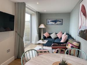 a living room with a couch and a table at La Pulente Cottages in St. Brelade