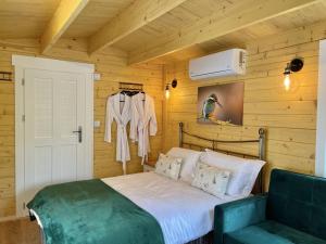 a bedroom with a bed in a wooden room at Willow Tree Lodge - Cosy lodge in the heart of the Kent countryside in Littlebourne