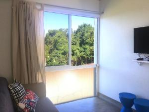 Una sala de estar con un gran ventanal con vistas. en Vila Praiana, en Ubatuba