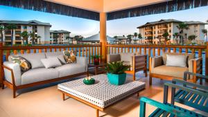 - une terrasse couverte avec 2 canapés, une table et des chaises dans l'établissement VG-Sun Deluxe Bungalow Cumbuco Beach View Top WiFi, à Cumbuco