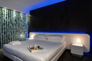 Un dormitorio con una cama con una bandeja de comida. en A Point Porto Ercole Resort & Spa en Porto Ercole