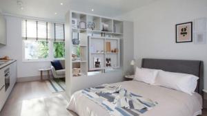 1 dormitorio con 1 cama grande y cocina en The Roundabout Hideout Room 1, en Zaragoza