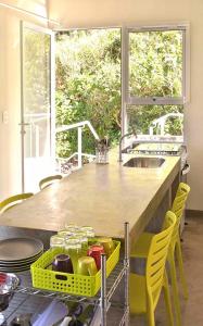 cocina con encimera con sillas amarillas y fregadero en Vila Praiana, en Ubatuba