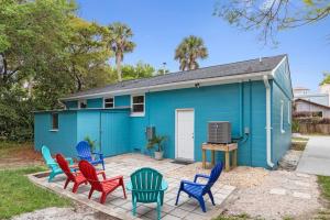 a blue house with colorful chairs in front of it at 208 W Ashley - Central Location - 2 Mins to the Beach in Folly Beach