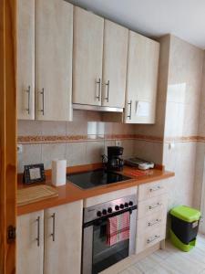 a kitchen with white cabinets and a stove top oven at Home&Holidays Las Gabias, Granada in Las Gabias