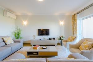 a living room with couches and a tv at Boavista Golf and Spa Resort - Bayview in Lagos