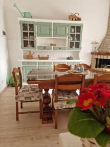 a kitchen with green cabinets and a table and chairs at La Casa dei Fiori in Assisi