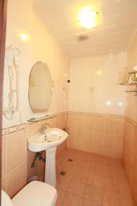 un bagno con lavandino, WC e specchio di Hualian Manpo B&B a Città di Hualien