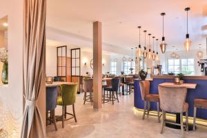 ein Restaurant mit Tischen und Stühlen und einer Bar in der Unterkunft Hotel JUMAs in Bad Zwischenahn