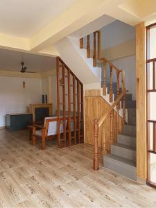 a living room with wooden stairs and a table at Stay Salty in Gaafaru