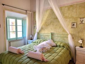 a bedroom with a green bed with a canopy at Residenza storica il Pozzo in San Quirico dʼOrcia