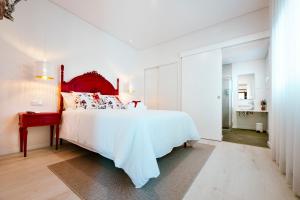 Schlafzimmer mit einem großen weißen Bett mit einem roten Kopfteil in der Unterkunft Delmira Vineyard House in Águas de Moura + 30 Fotos