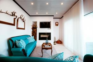 - un salon avec un canapé bleu et une table dans l'établissement Delmira Vineyard House, à Águas de Moura