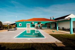 ein Haus mit einem Swimmingpool davor in der Unterkunft Delmira Vineyard House in Águas de Moura